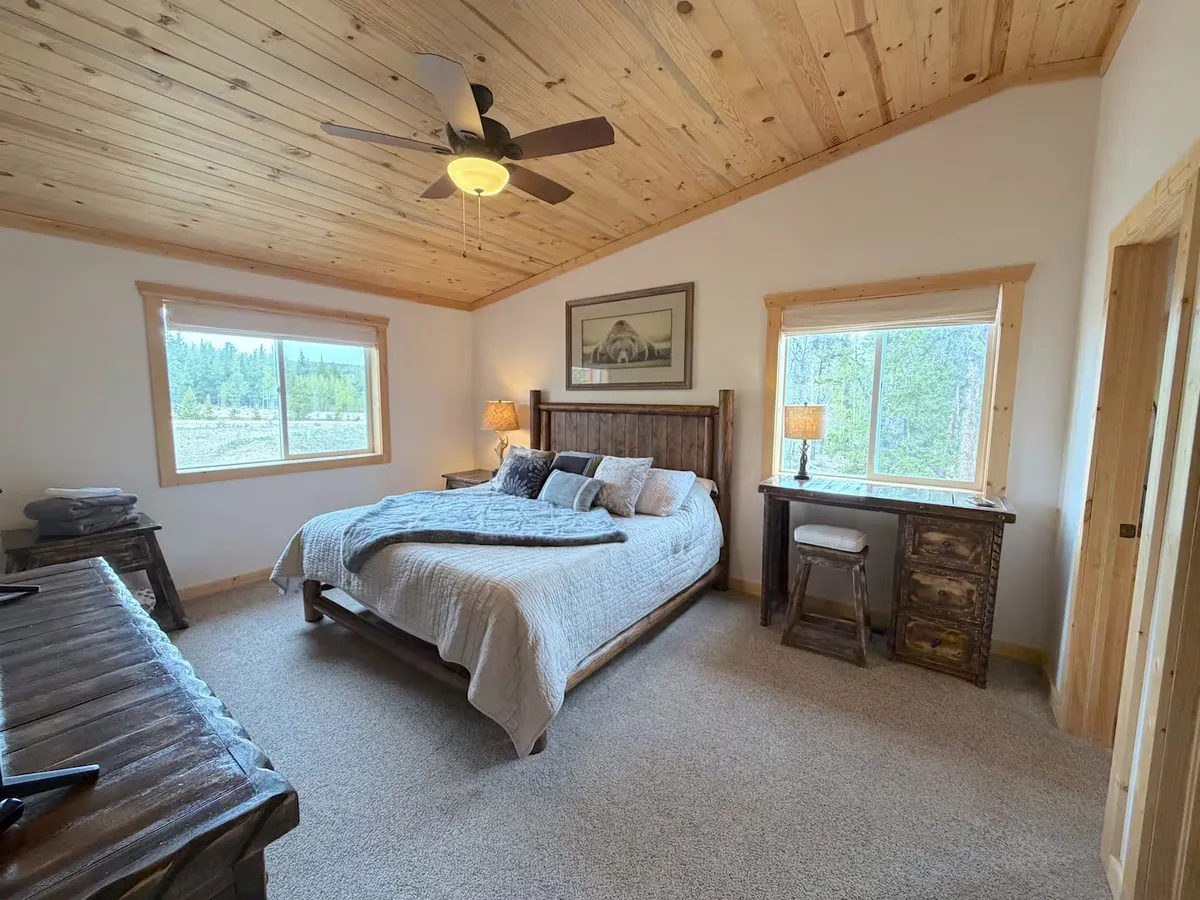 Primary bedroom with king-size bed and forest views — Foxtail Stay cabin near Breckenridge, CO