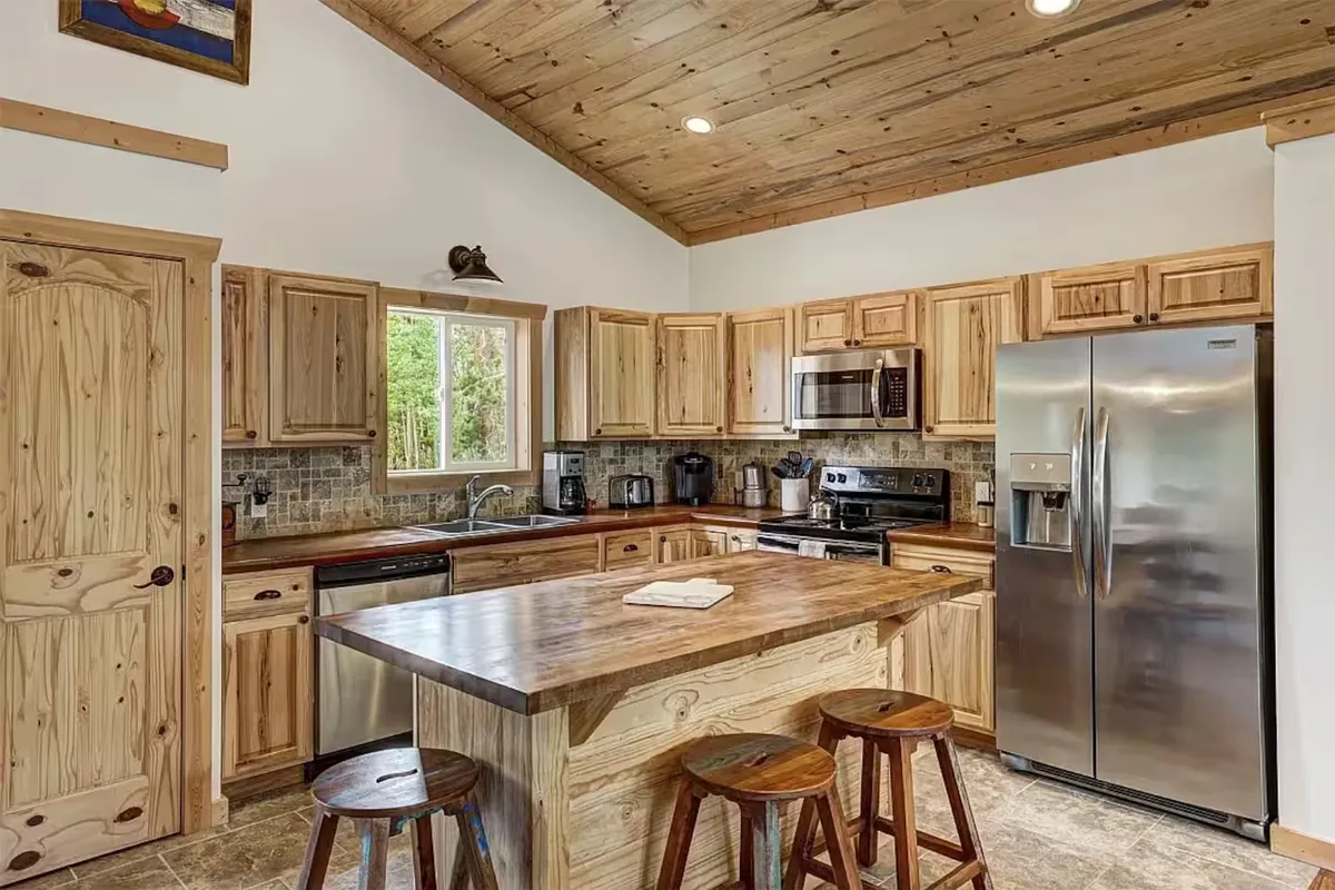 Open-plan kitchen and dining area with wood finishes and breakfast bar inside the Fairplay cabin